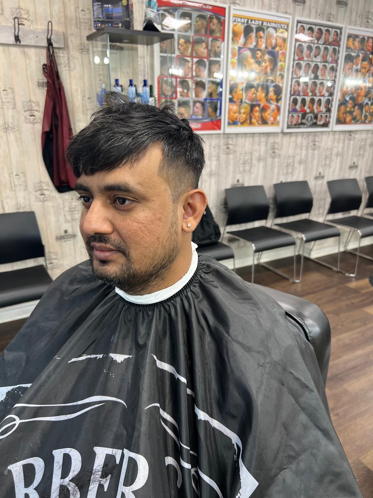 Client with a mid fade and textured top in the barber chair