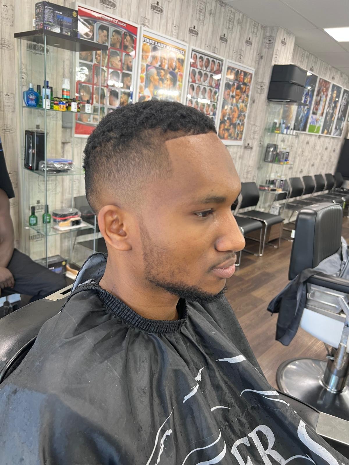 Low taper fade with a clean hairline, side profile